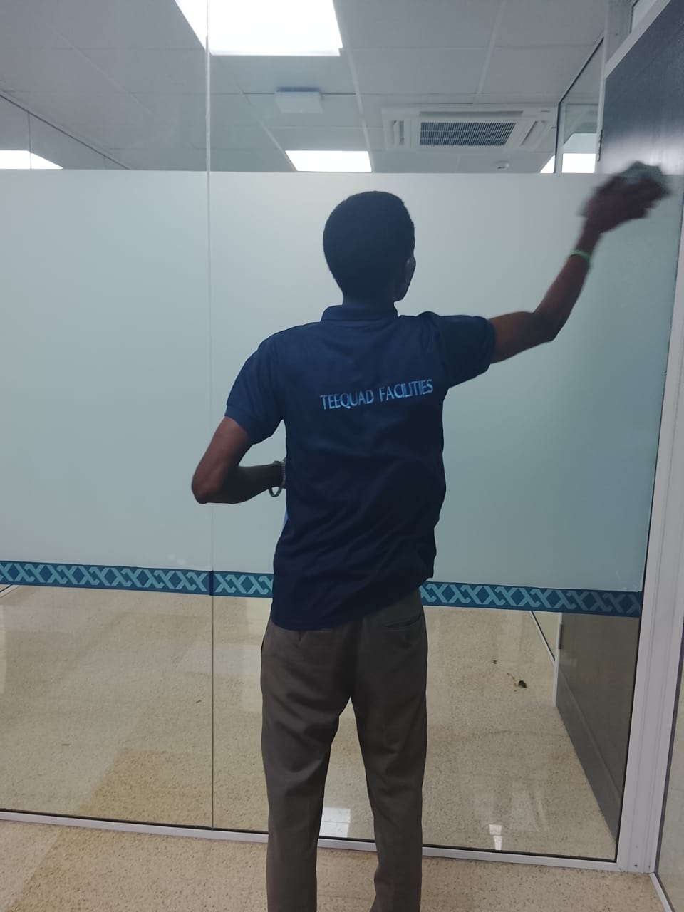 TEEQUAD facilities crew polishing glass partition